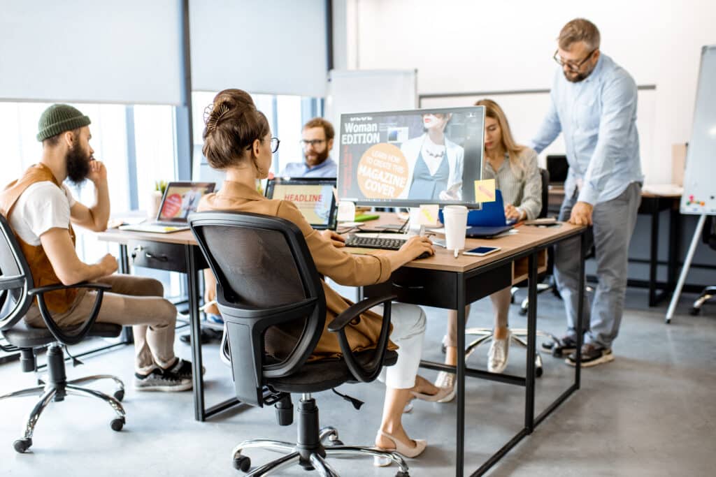 Eine Gruppe Webdesigner sitzt im Büro und arbeitet