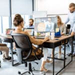 Eine Gruppe Webdesigner sitzt im Büro und arbeitet